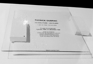 Front dépressif abstrait, 2011 acrylique sur verre, assemblage avec le livre d'artiste de Patrick Dubrac : La sculpture : les pluies, édition incertain sens, 2003, source lumineuse, diffraction, ombre projetée, divers éléments. 30 x30 x 5 cm